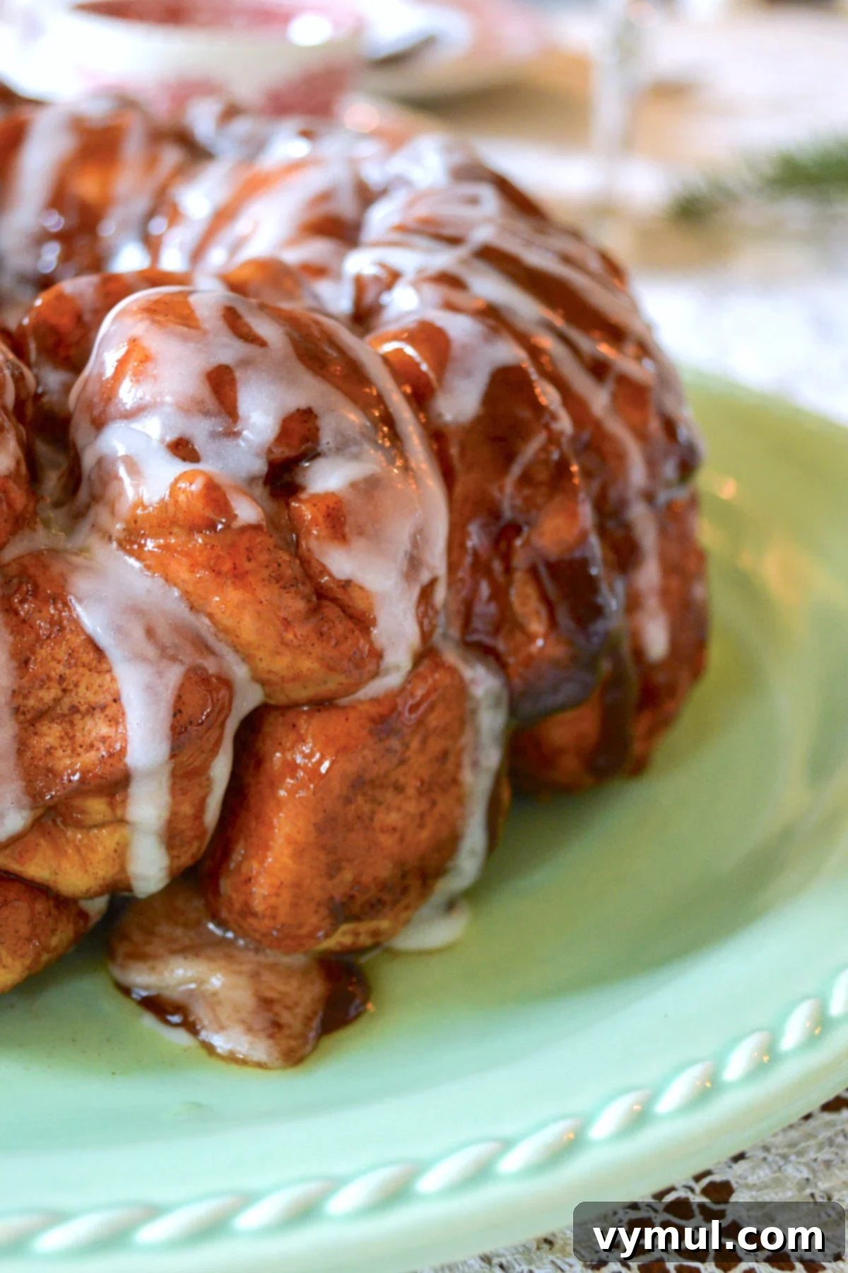 close up of monkey bread on green plate, showing gooey cinnamon sugar coating