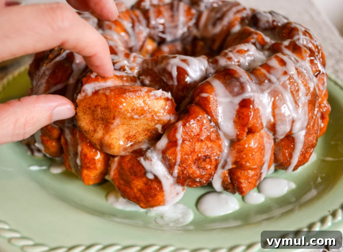 pulling a piece of monkey bread from loaf, showing its soft texture