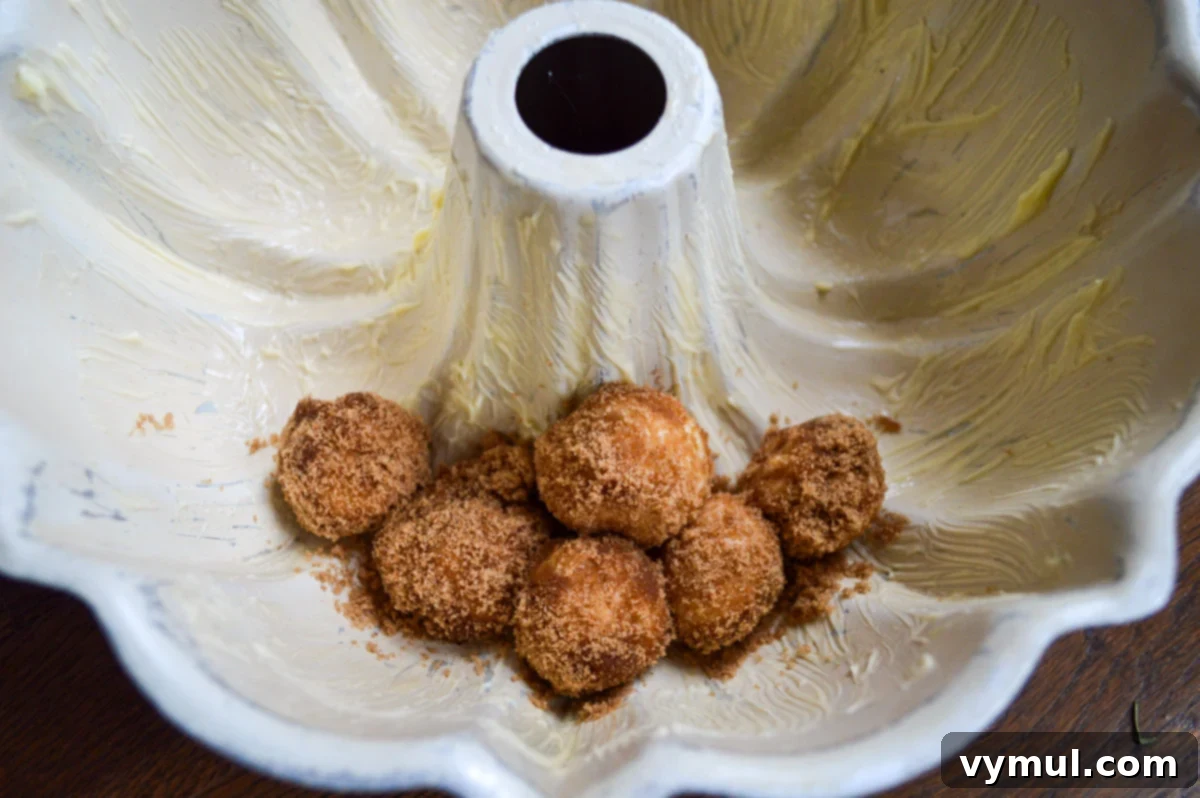 first coated dough balls layered in a buttered bundt pan