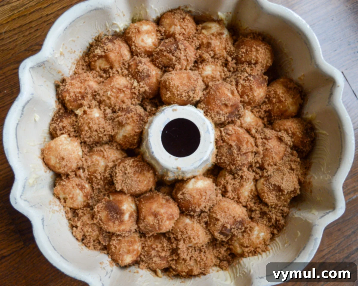full bundt pan with sugar coated dough balls, ready for rising
