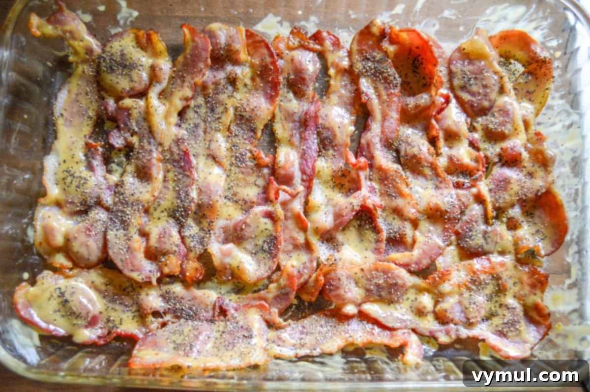 mustard coated bacon in glass baking pan