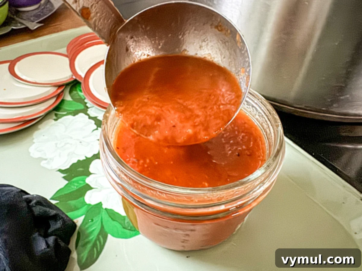 Simple Homemade Pizza Sauce for Canning Fresh or Frozen Tomatoes 11 Adding pizza sauce to canning jar