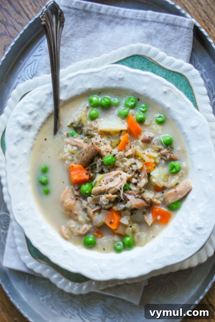 Effortless Creamy Turkey and Chicken Rice Soup 2 white bowl of creamy turkey or chicken rice soup from above, garnished with fresh herbs