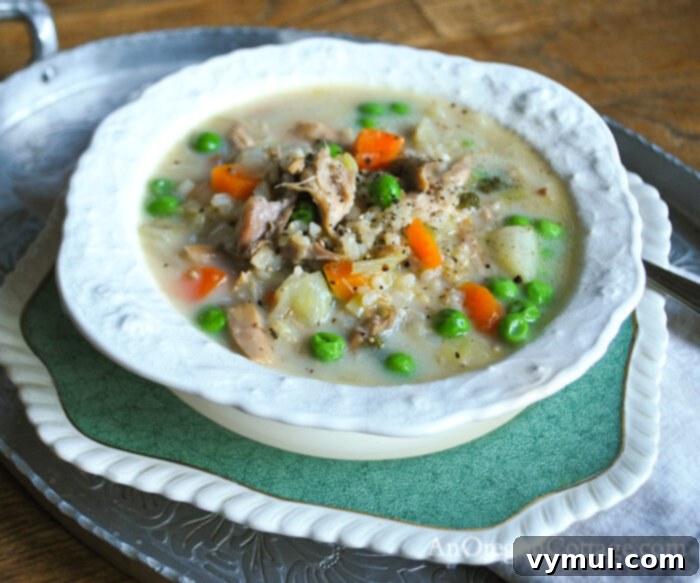 Effortless Creamy Turkey and Chicken Rice Soup 3 creamy turkey rice soup in white bowl from side, showing rich texture