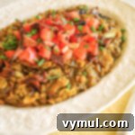 Bacon Lentil Curry with Golden Cabbage 8 A vibrant bowl of curried lentils with bacon and browned cabbage, garnished with fresh tomatoes, ready to be served as a healthy, nourishing dinner. Perfect for a weeknight meal or comforting leftovers.