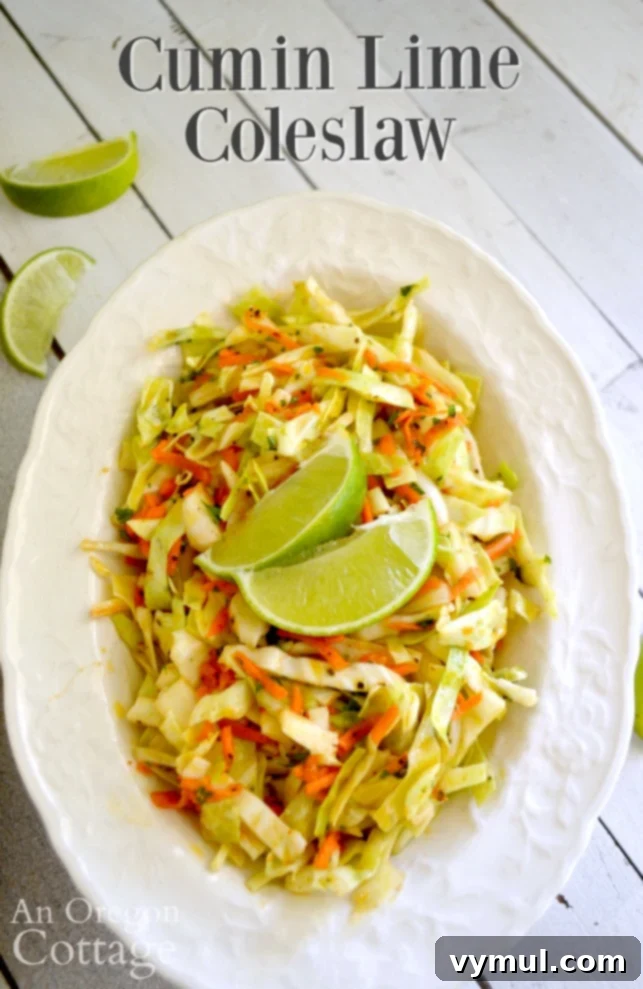 A vibrant bowl of Spicy Cumin Lime Coleslaw, featuring shredded cabbage, carrots, and fresh herbs, glistening with a zesty vinaigrette.