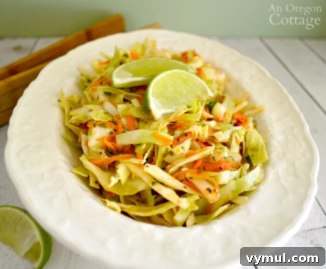 A close-up of a serving bowl filled with Spicy Cumin Lime Slaw, highlighting the fresh texture and vibrant colors of the ingredients.