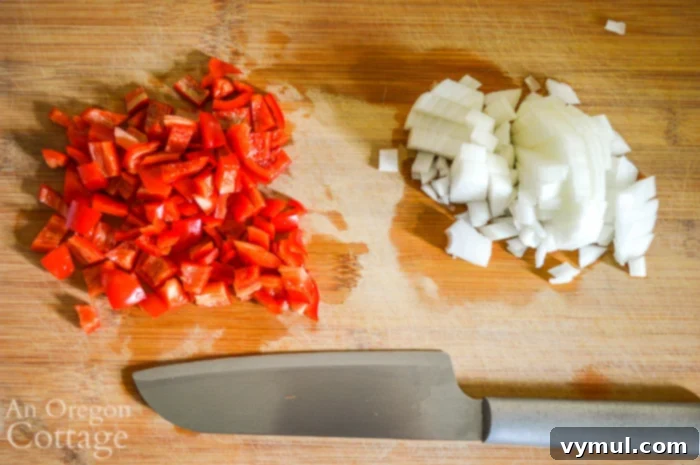 Freshly chopped bell peppers and onions, ready for sautéing in a vibrant mix.