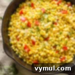 Vibrant Corn, Pepper, and Onion Sauté in a pan, steaming hot and ready to serve.