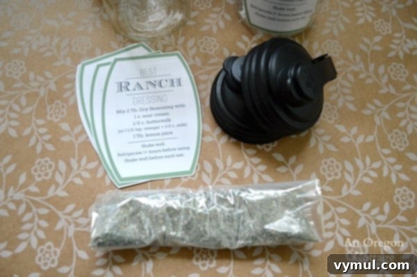 Ranch Dressing Gifts from Your Kitchen 3 Ranch Salad Dressing Mason Jar Gift components: three mason jars with pour lids, small baggies of dry ranch seasoning mix, and custom printable recipe tags spread on a wooden surface.