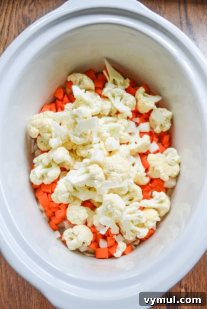 Adding vegetables to white slow cooker