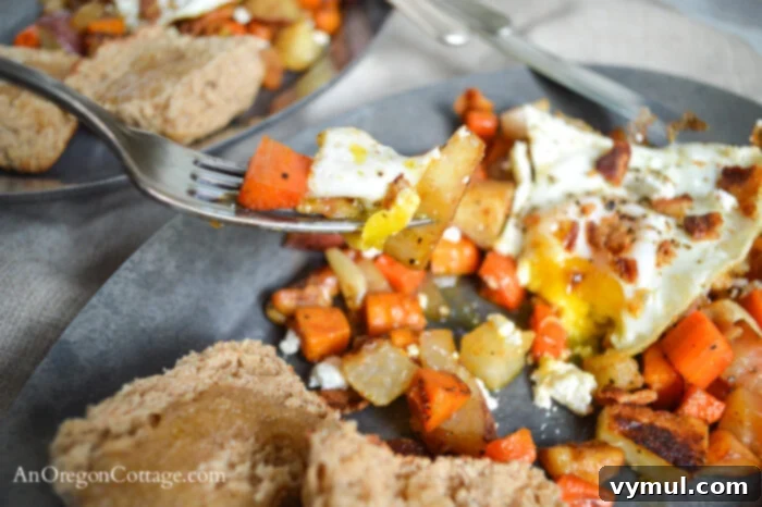 Close-up of roasted root vegetable hash on a fork, showing pieces of sweet potato, carrot, and beet