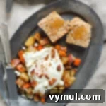 Roasted root vegetable hash on plates with fried eggs