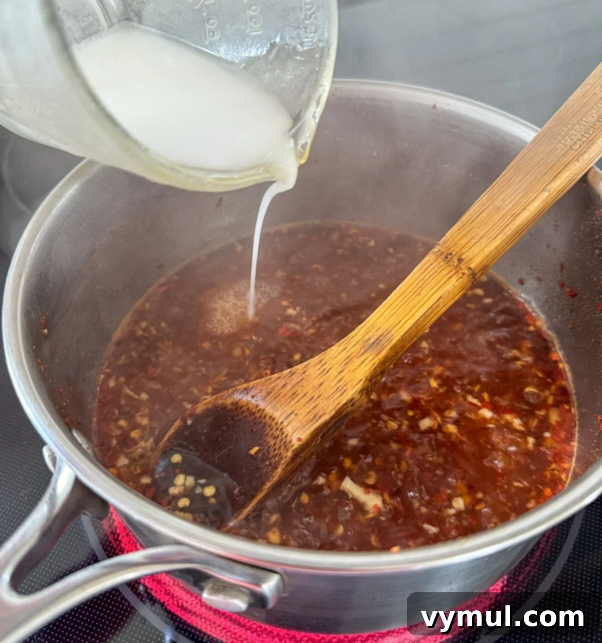 adding starch slurry to boiling chili sauce