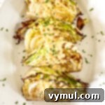 Roasted cabbage wedges on a white platter, drizzled with creamy onion-Dijon sauce.