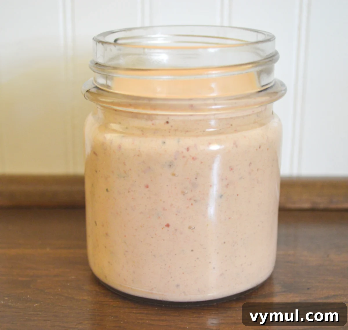 A glass jar filled with luscious, creamy chipotle sauce, ready to be served with grilled shrimp tacos.
