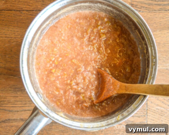 Handcrafted Honey Rhubarb Ginger Preserve 4 Cooking homemade honey rhubarb ginger jam in a large saucepan on the stovetop, bubbling gently