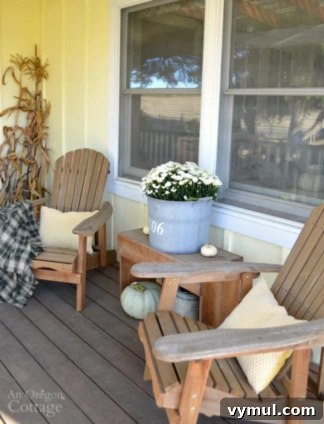 Fall Porch with easy Adirondack chair fall decor, pumpkins, and a warm drink.