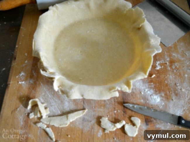 Trimming the edges of the pie crust for a neat and even finish before shaping.