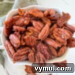 maple candied pecans in white bowl, top-down view