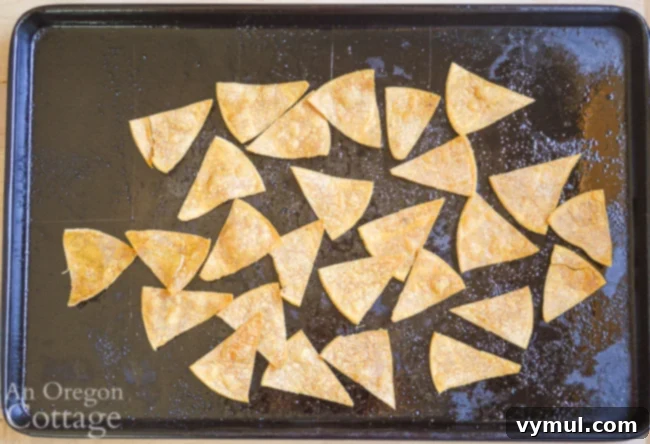 Homemade Crispy Tortilla Chips in Just 10 Minutes 5 Freshly baked tortilla chips cooling on a baking pan.