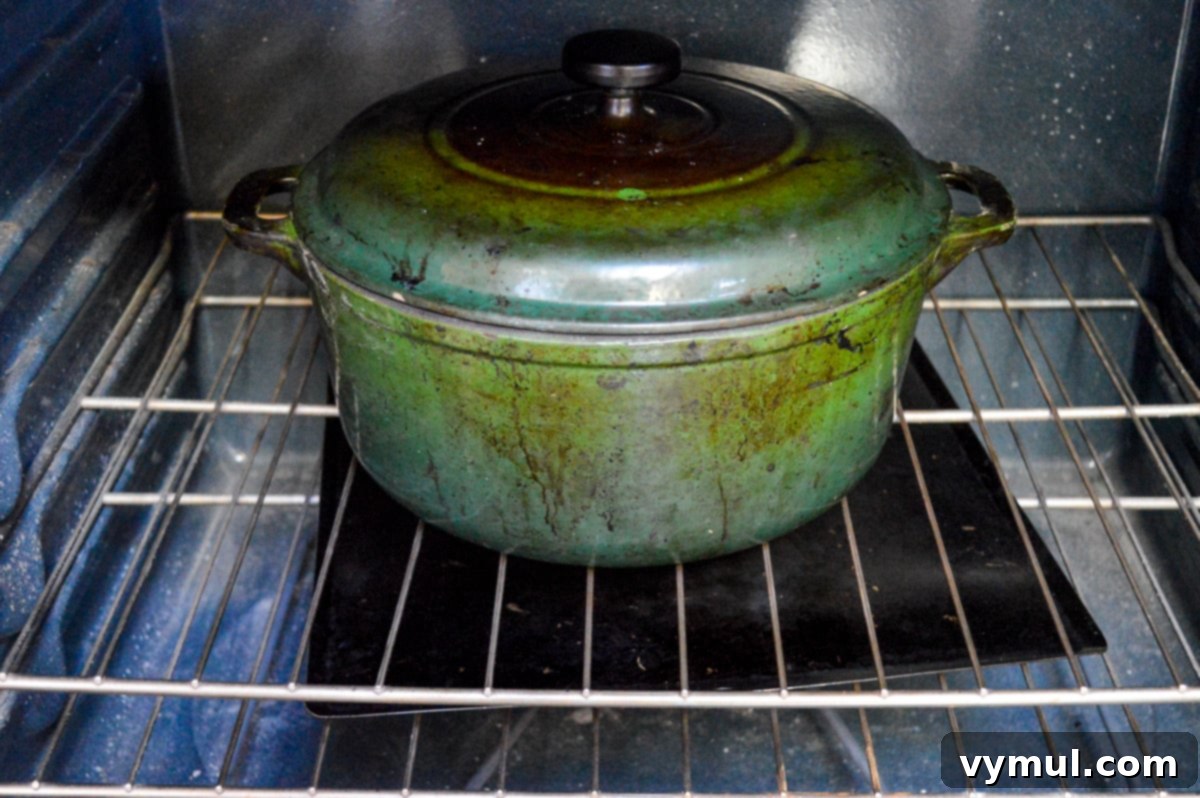 The One-Day Sourdough Secret: Artisan Bread Made Simple 11 enameled cast iron pan heating empty in a cold oven, preparing for sourdough baking