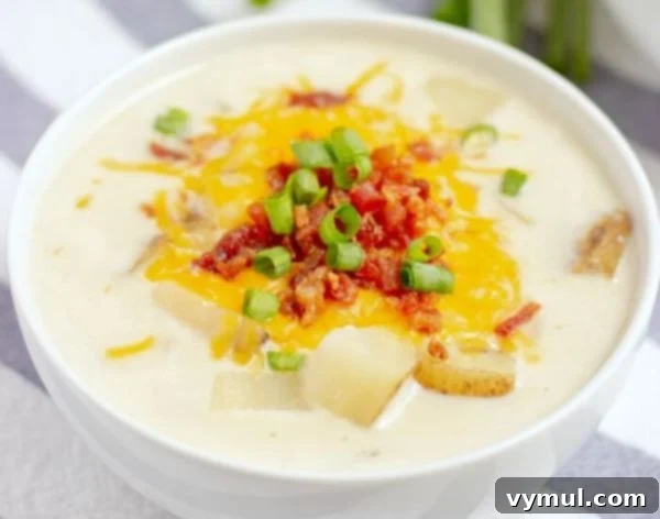 Baked potato soup in white bowl @Mama Loves Food