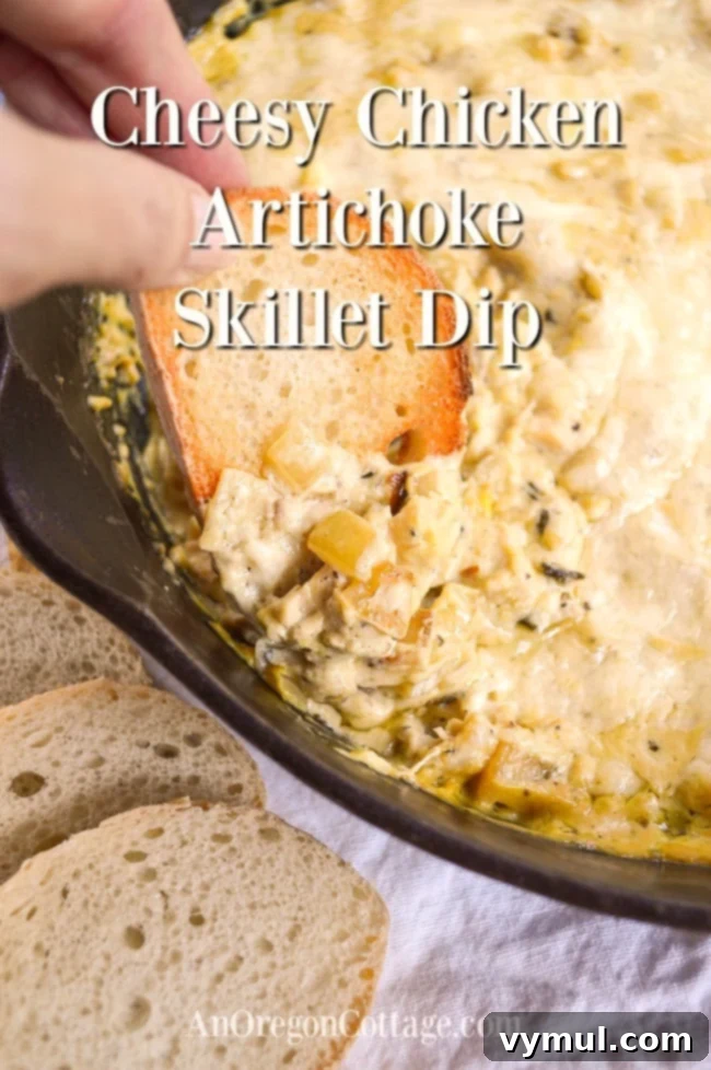Ultimate Cheesy Chicken Artichoke Skillet Dip 2 Scooping rich, creamy Cheesy Chicken Artichoke Skillet Dip from a cast iron pan