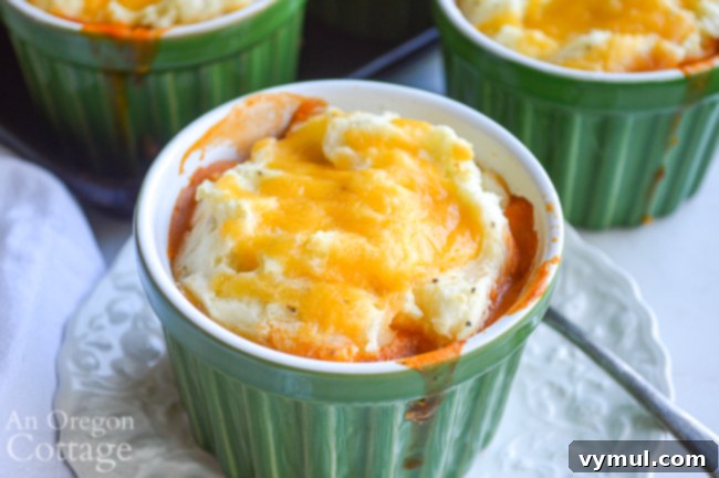 Hearty Chicken & Tomato Shepherd's Pie 3 Close-up shot of a baked Chicken Tomato Shepherd's Pie, showcasing the golden mashed potato topping and rich chicken filling.