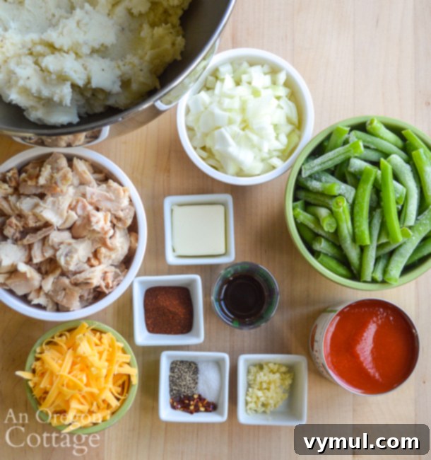 Hearty Chicken & Tomato Shepherd's Pie 4 A collection of fresh ingredients laid out for Chicken Tomato Shepherd's Pie, including chicken, onions, green beans, tomato sauce, and spices.