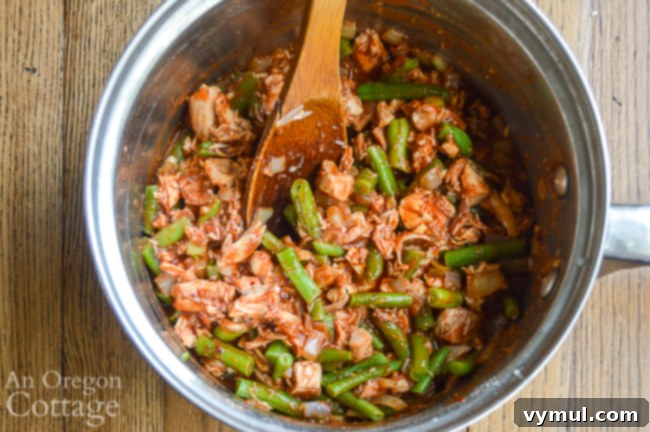 Hearty Chicken & Tomato Shepherd's Pie 5 The savory chicken and vegetable filling for Shepherd's Pie simmering in a large pan on the stovetop.