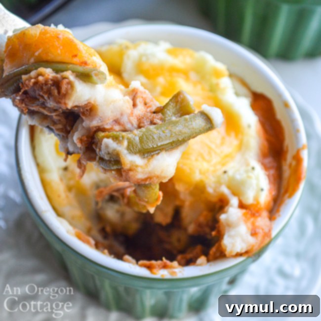 Hearty Chicken & Tomato Shepherd's Pie 7 A close-up of a spoonful of Chicken Tomato Shepherd's Pie, showing the layers of mashed potato, cheese, and rich chicken and vegetable filling. Ideal for a healthy, easy one-dish dinner.