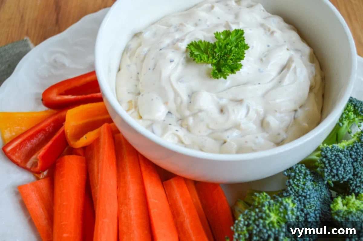 Best Ever Easy Homemade French Onion Dip 3 onion dip in white bowl with veggies from side