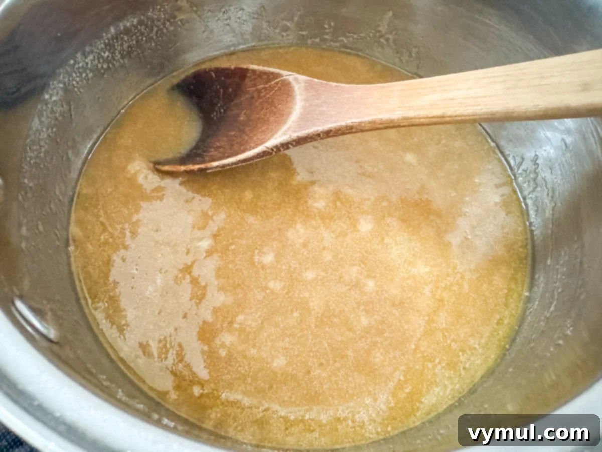 Foolproof Moose Munch Caramel Corn No Corn Syrup No Thermometer 6 Butter, granulated sugar, brown sugar, and honey melting together in a saucepan over medium heat for caramel preparation.