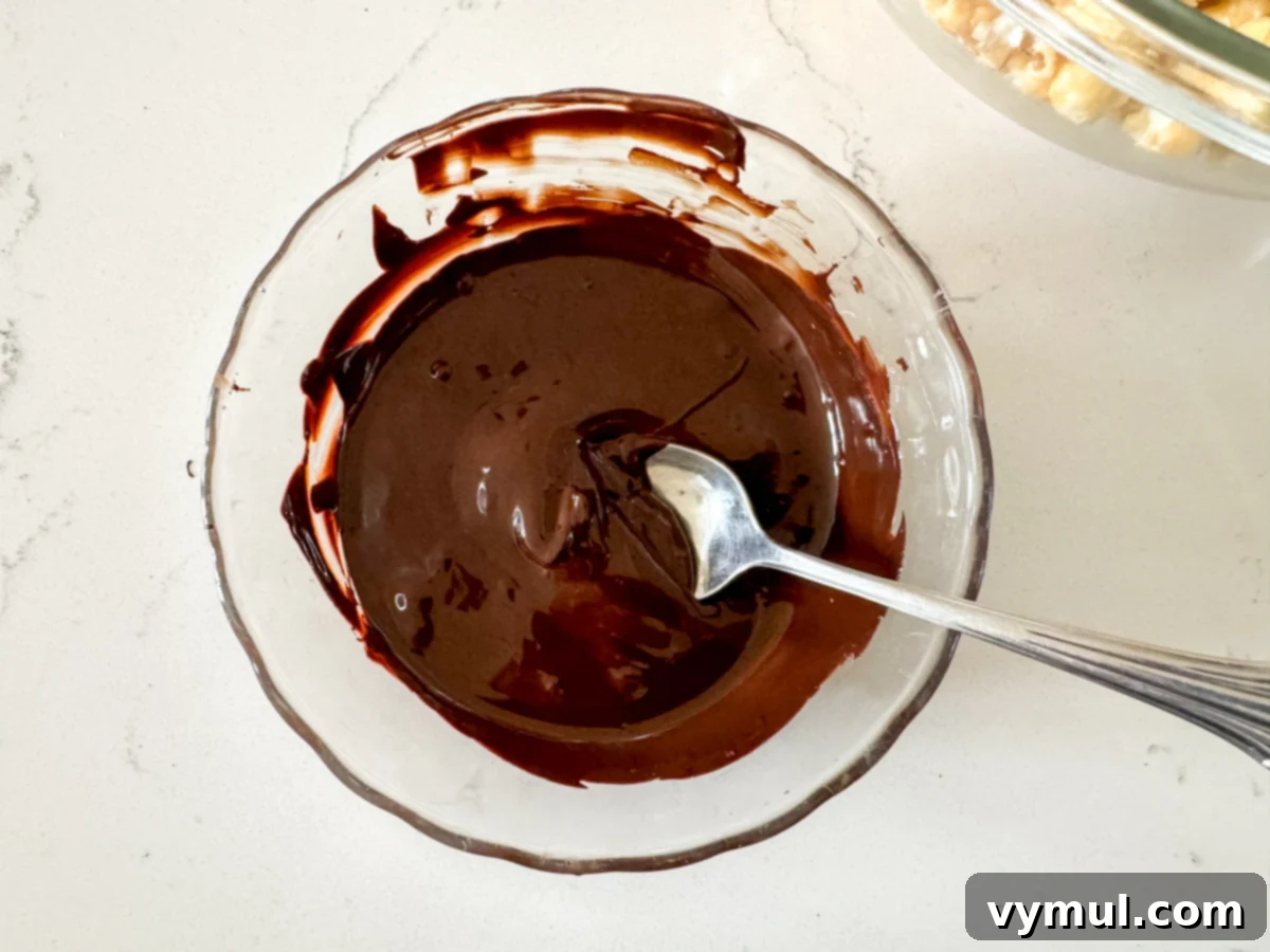 Foolproof Moose Munch Caramel Corn No Corn Syrup No Thermometer 10 Smooth, melted chocolate chips in a clear bowl, ready for coating the caramel corn.