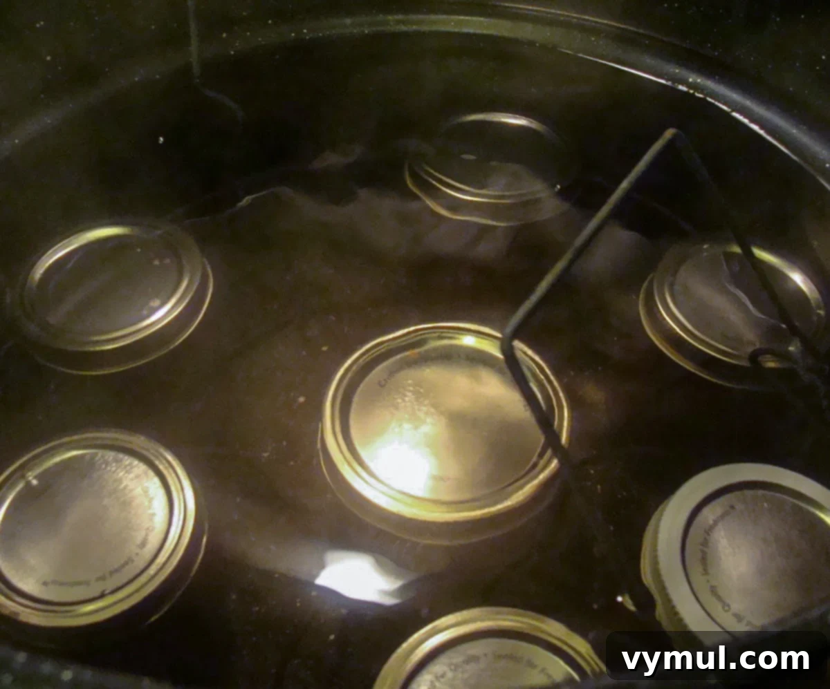 Canning jars submerged in a water bath canner, boiling