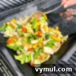 stirring grilled vegetables in basket