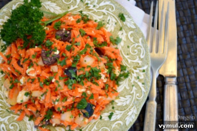 Mastering August: Seasonal Recipes, Expert Tips and Your Printable Planner 4 Bright and colorful Carrot Feta Olive salad on a white plate, ready to be served.