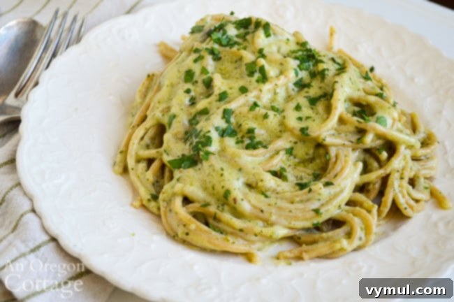 Mastering August: Seasonal Recipes, Expert Tips and Your Printable Planner 6 Creamy Pesto Pasta on a white plate, garnished with fresh basil leaves.