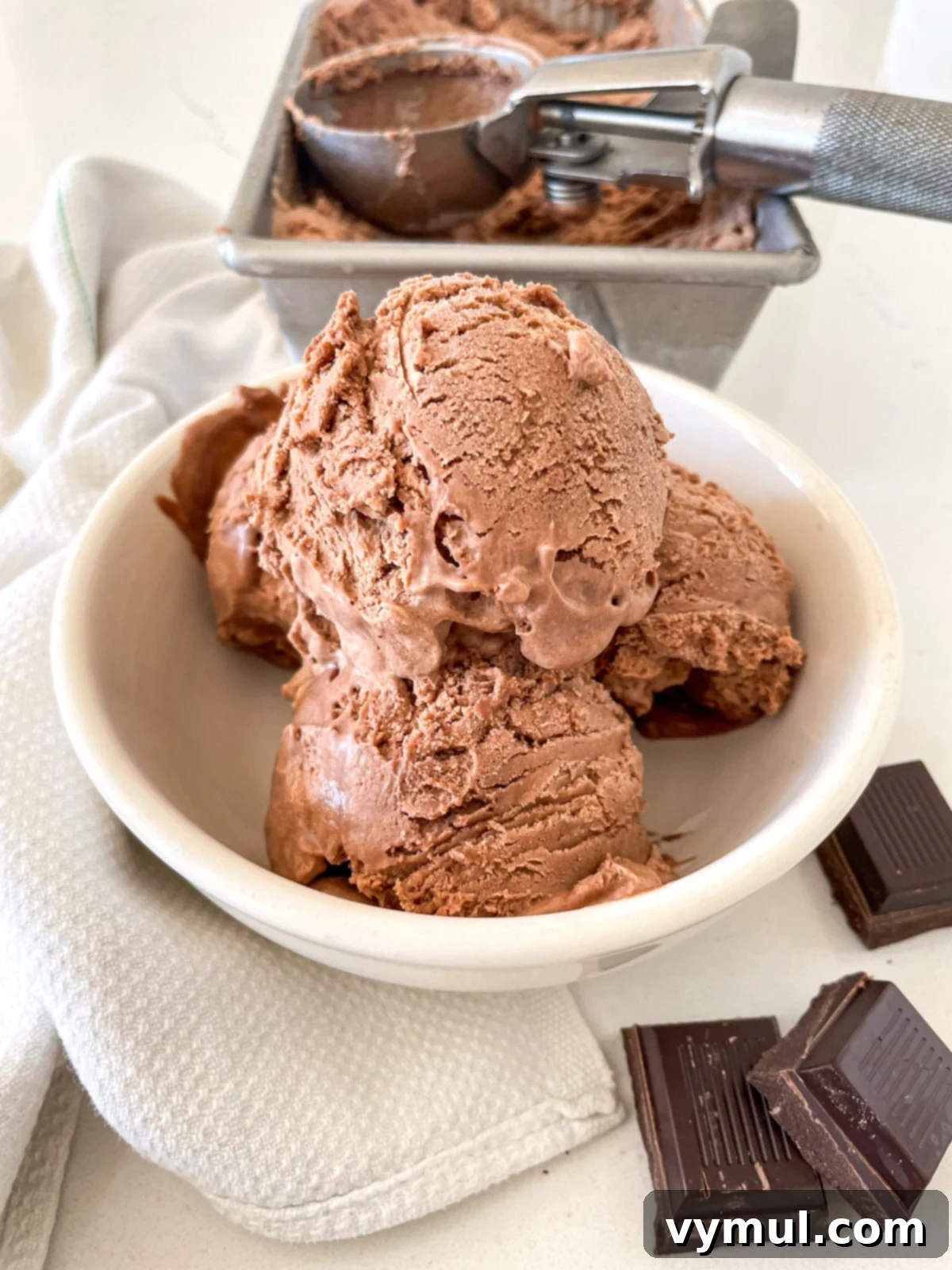Three generous scoops of no-churn chocolate ice cream in a white bowl, garnished.