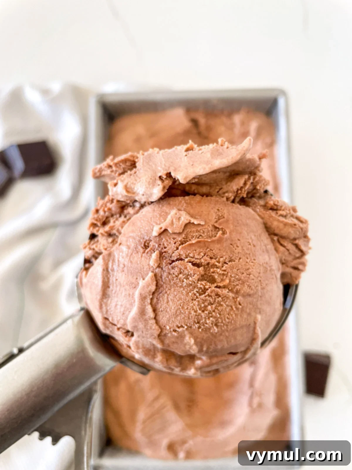 Close-up of decadent chocolate ice cream being scooped, highlighting its smooth texture.