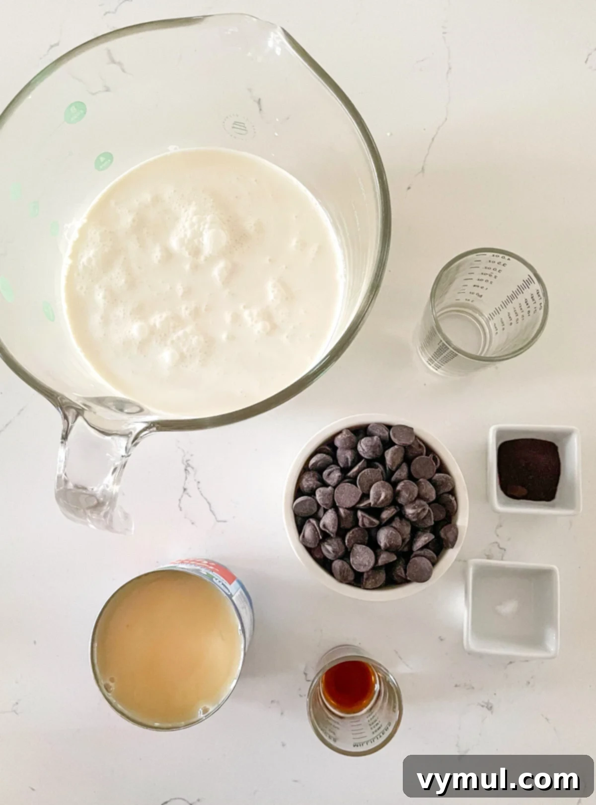 The five essential ingredients for no-churn chocolate ice cream laid out on a surface.