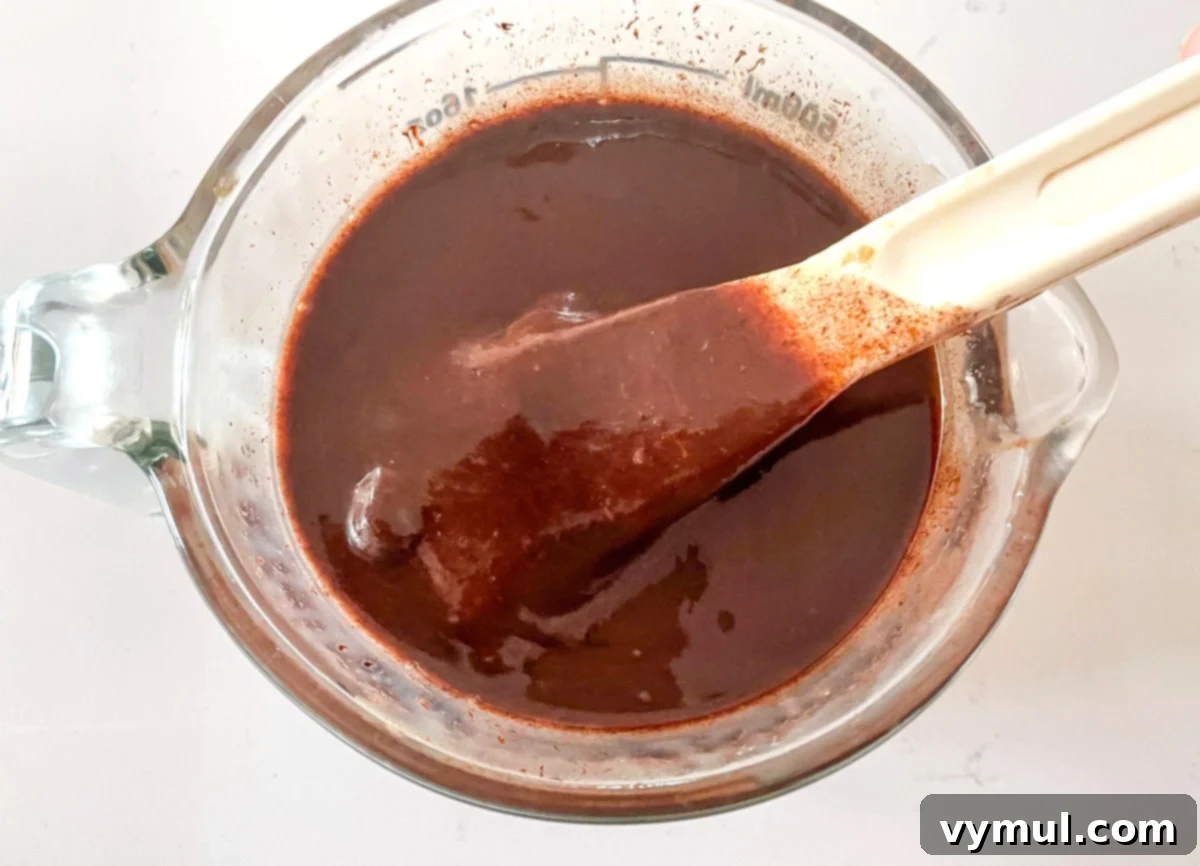 Sweetened condensed milk and chocolate pieces in a bowl, ready to be melted.