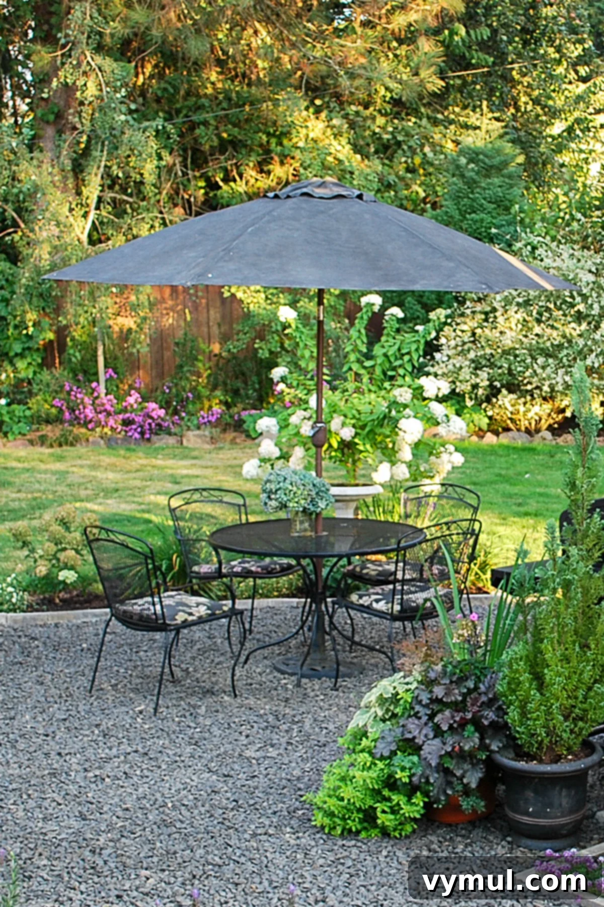 Sun-Kissed No More: Painting Your Outdoor Umbrella for Lasting Vibrancy 2 painted black outdoor umbrella on gravel patio with green plants