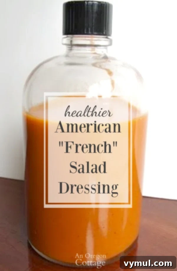 Tomato-based French dressing for salads made healthier with a lot less sugar and only real food ingredients. A vibrant red dressing in a glass jar, next to fresh salad greens and tomatoes.