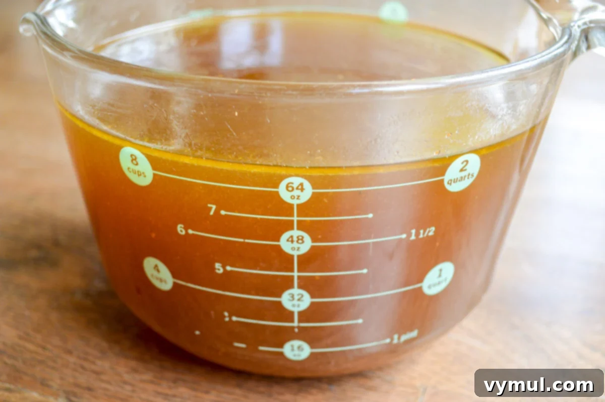 chicken broth in 8-cup glass measuring cup