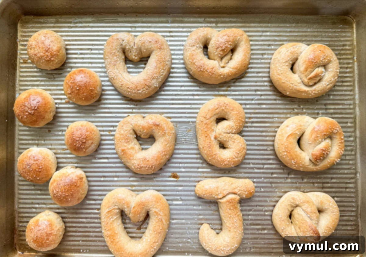 Homemade Soft Pretzels: Quick and Easy in 30 Minutes 11 various shaped baked pretzels on a cookie sheet, including letters and traditional knots
