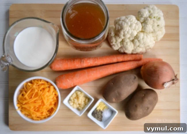 Amazing 30-Minute Cauliflower Cheese Soup 4 A selection of fresh, simple ingredients laid out for making cauliflower cheese soup: chicken stock, potatoes, onion, carrots, garlic, cauliflower, salt, dry mustard, black pepper, cheddar cheese, and milk.