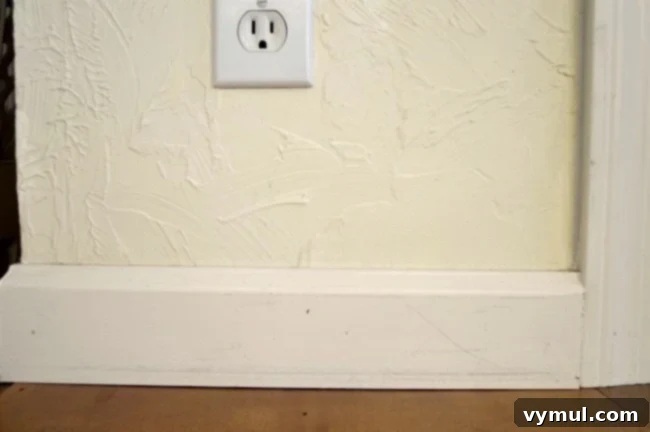 Before image of dingy white baseboards needing touch-up paint