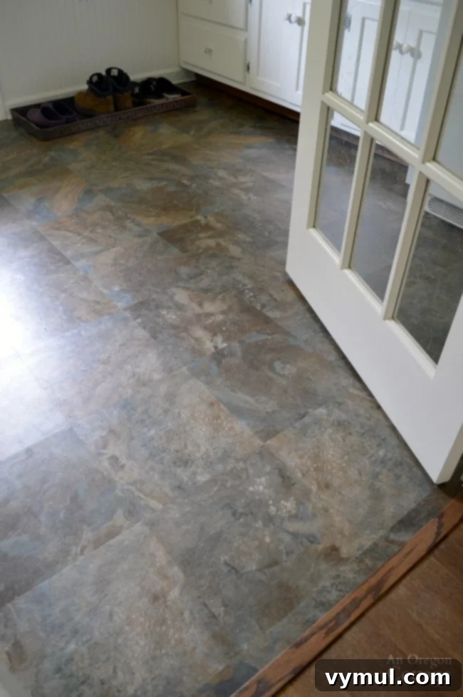After photo of a cottage farmhouse laundry room floor with new slate-look peel-and-stick tiles, offering durability.